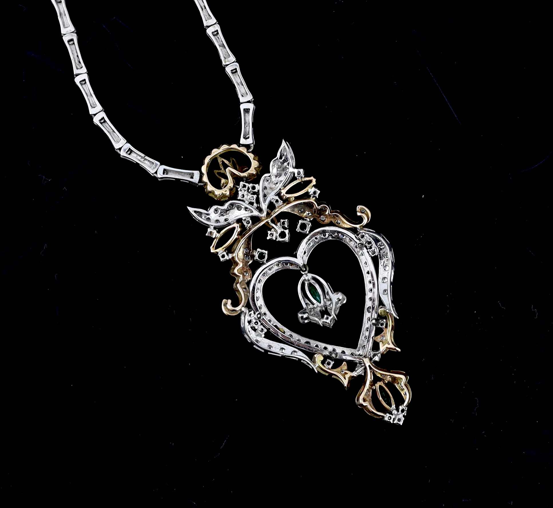 A late 20th century Middle Eastern two colour gold, emerald and diamond cluster heart shaped pendant necklace